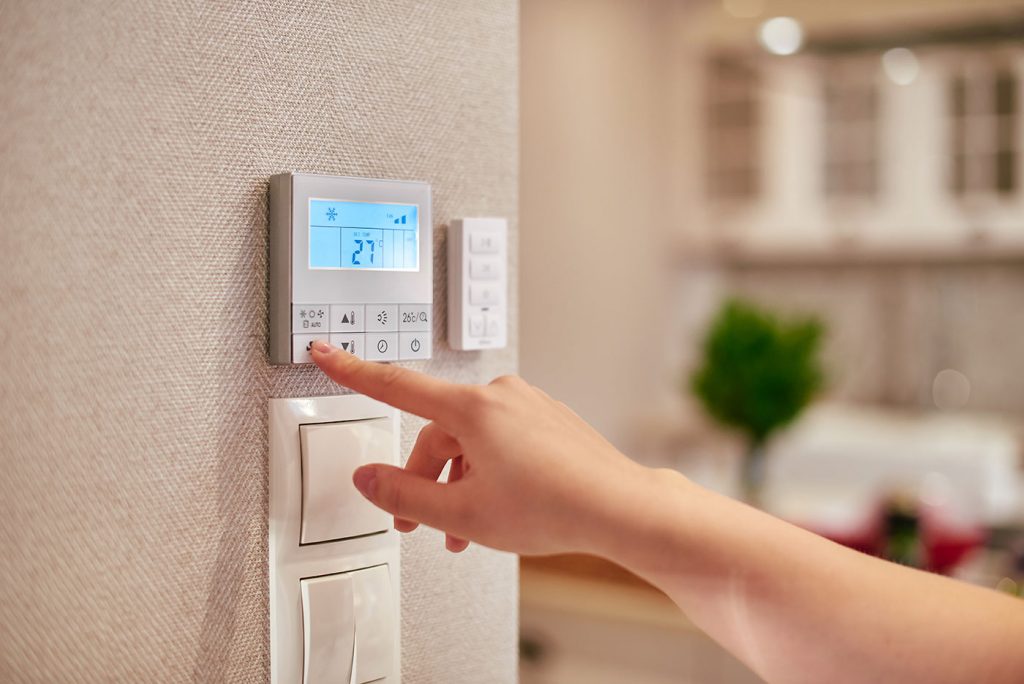 woman using thermostat